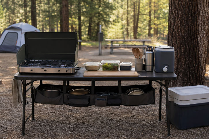 camp kitchen setup with stove and cooler at campsite