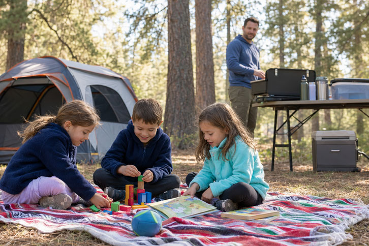 How to Set Up the Perfect Family Campsite (Step by Step) - kids playing near camp kitchen while parent cooks