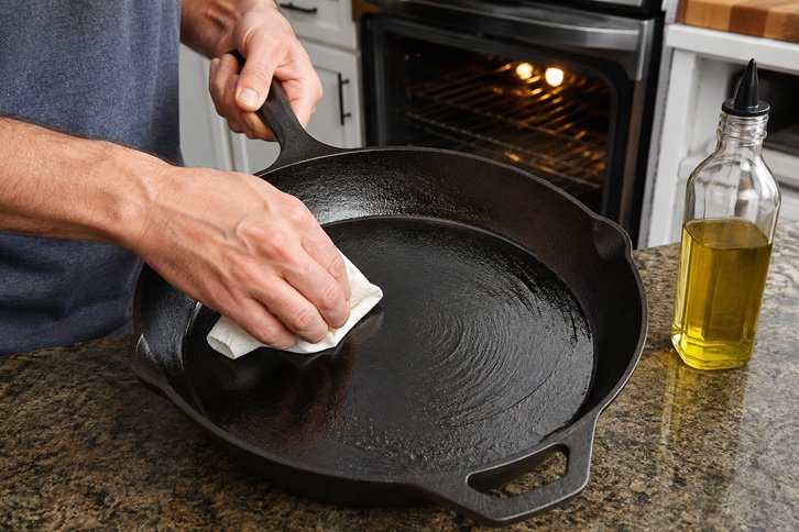 Seasoning a bare cast iron skillet with oil before a camping trip