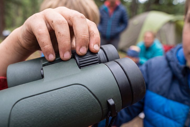 kid adjusting focus wheel on compact kids binoculars - best binoculars kids