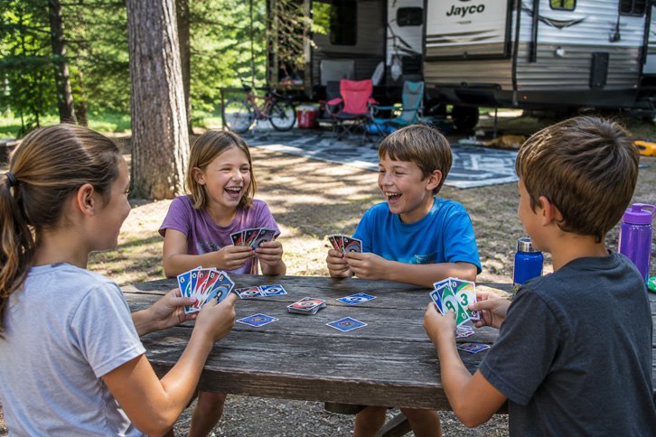 Kids playing a card game at the campsite to avoid boredom while camping